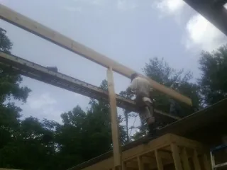 Carpenter setting a ridge beam over a new addition frame — Ice Dam Removal by Roofing Brothers in Kenton