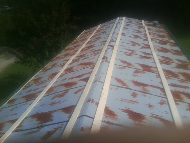Rusted metal roof panels with new wood purlins before replacement — Storm Damage Roof Repair in Kenton by Roofing Brothers